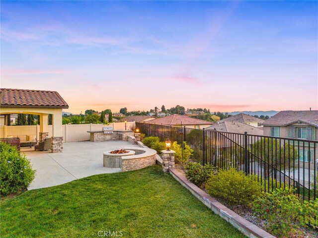 yard at dusk featuring a patio and an outdoor living space with a fire pit
