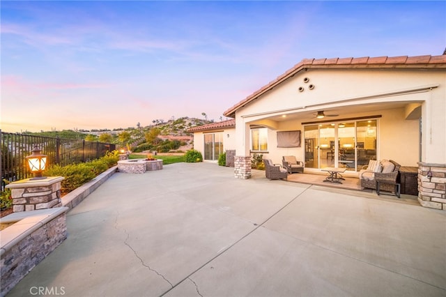 patio terrace at dusk featuring fence and an outdoor hangout area