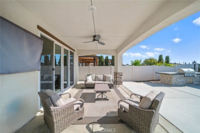 view of patio featuring exterior kitchen, outdoor lounge area, a fenced backyard, area for grilling, and ceiling fan