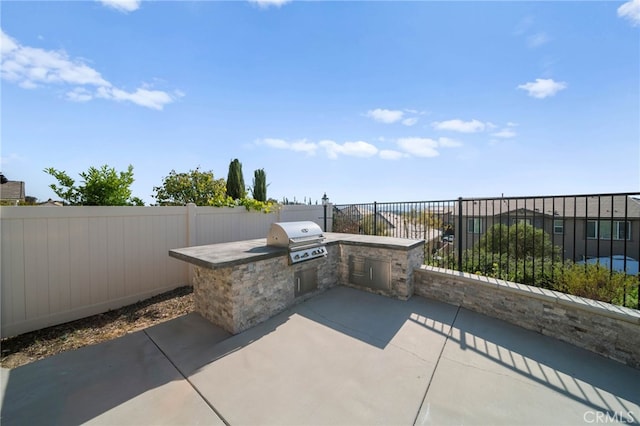 view of patio with area for grilling and a fenced backyard