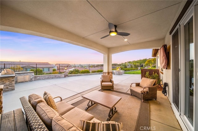 view of patio / terrace featuring an outdoor kitchen, an outdoor hangout area, a fenced backyard, and a ceiling fan