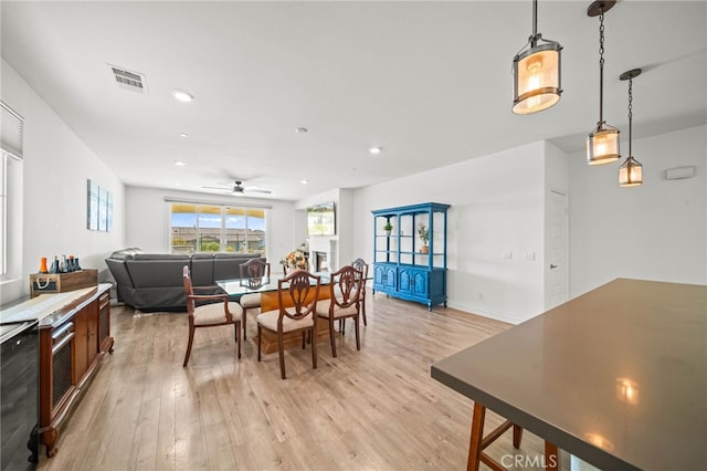 dining space with light wood finished floors, a ceiling fan, recessed lighting, and wine cooler