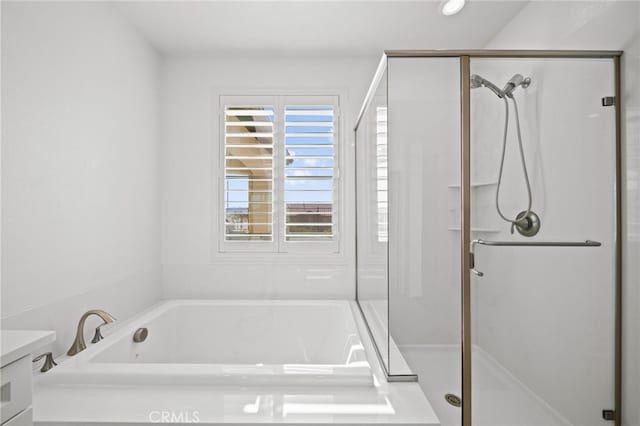 full bathroom with a shower stall, a bath, and vanity