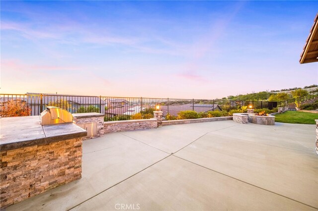 40571 Alder Ct, Temecula, CA 92591 - view of patio / terrace with an outdoor kitchen, a fire pit, and a fenced backyard
