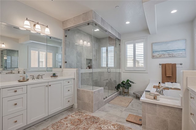 bathroom with a stall shower, vanity, a wealth of natural light, and a garden tub