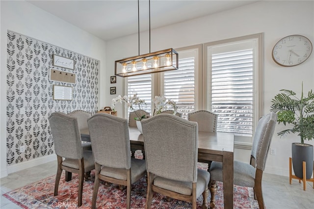 dining space featuring a notable chandelier and baseboards
