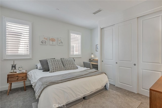 bedroom featuring a closet, visible vents, and light colored carpet