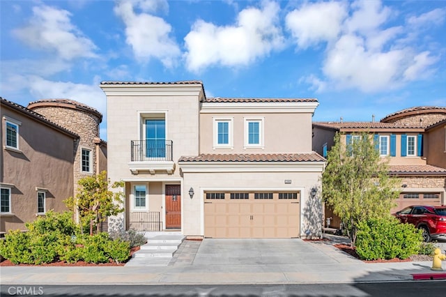 view of front of home featuring an attached garage, a balcony, concrete driveway, stucco siding, and a tiled roof