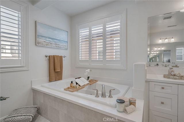 full bath featuring a bath, a wealth of natural light, and vanity