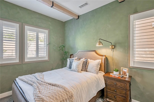 bedroom featuring beam ceiling, visible vents, and baseboards