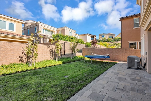 view of yard featuring a patio, central AC, a trampoline, a residential view, and fence private yard
