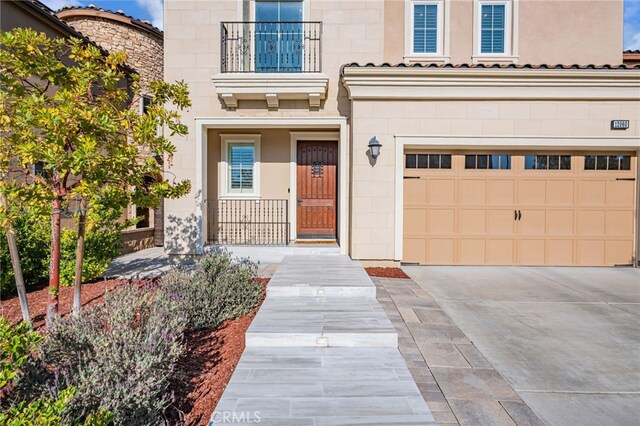 doorway to property featuring concrete driveway, an attached garage, and stone siding