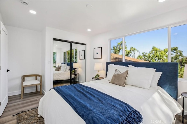 bedroom with multiple windows, recessed lighting, and wood finished floors