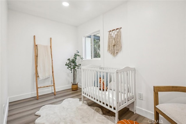 bedroom with baseboards, recessed lighting, and wood finished floors
