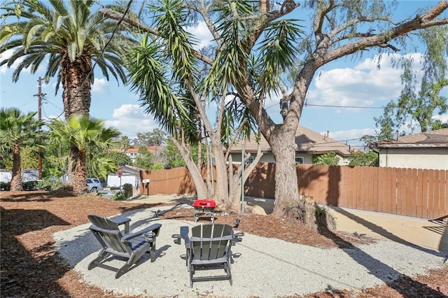 view of yard with a fire pit and fence