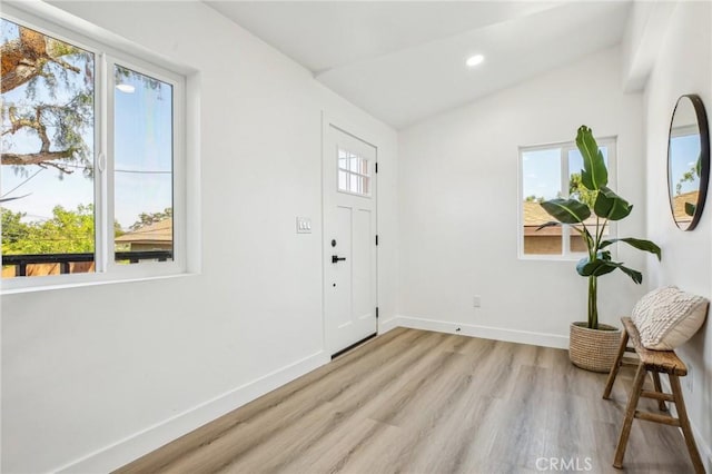 entryway with lofted ceiling, baseboards, light wood-style flooring, and plenty of natural light