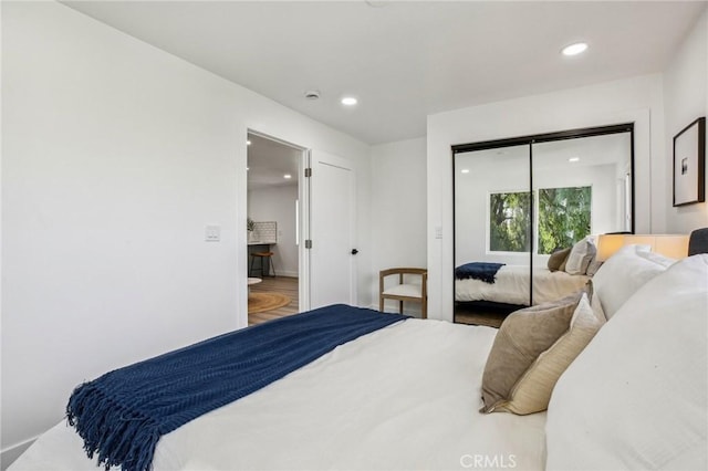 bedroom with wood finished floors, a closet, and recessed lighting