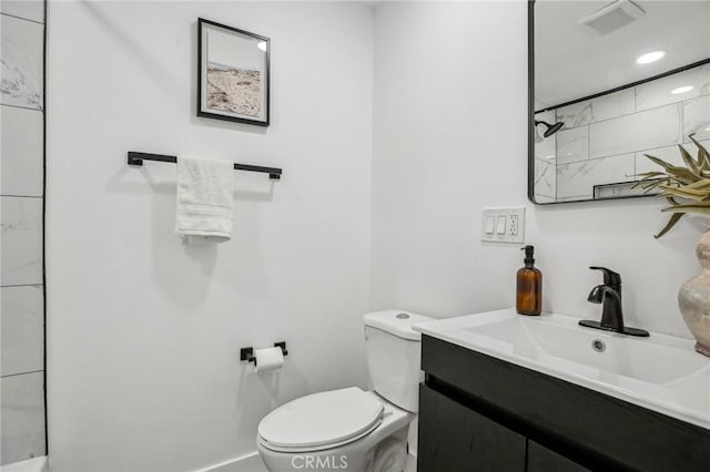bathroom featuring toilet, a shower, vanity, and visible vents