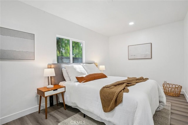 bedroom with recessed lighting, baseboards, and wood finished floors