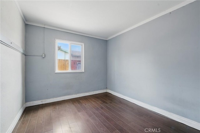 spare room featuring ornamental molding, baseboards, and hardwood / wood-style floors