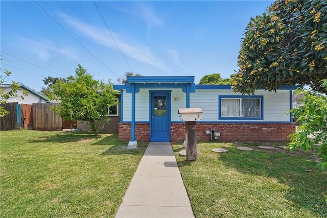 view of front of house with brick siding, fence, and a front yard