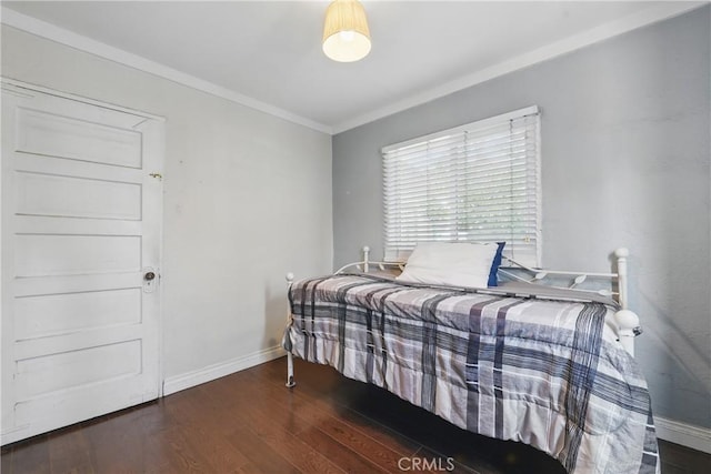 bedroom featuring baseboards, ornamental molding, and wood finished floors