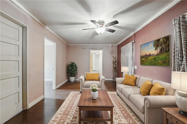 living area featuring crown molding, wood finished floors, baseboards, and ceiling fan