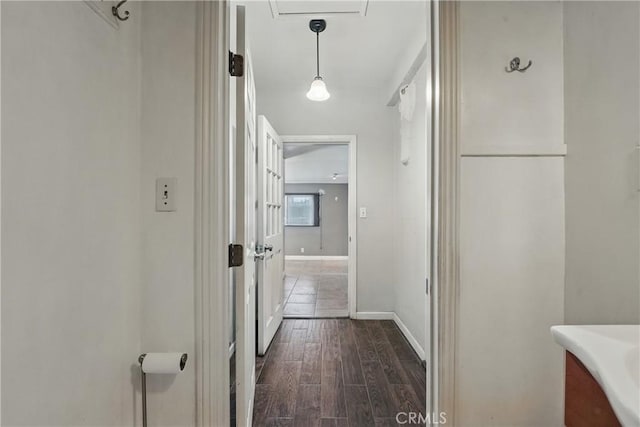 hallway with dark wood-style flooring and baseboards