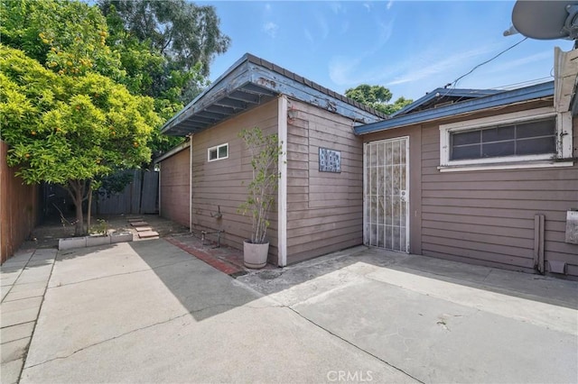 view of side of home featuring a fenced backyard, a patio area, and solar panels