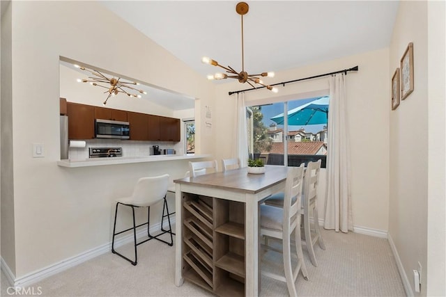 44 Corniche Dr Unit G, Dana Point, CA 92629 - dining area featuring a chandelier, light carpet, lofted ceiling, and baseboards