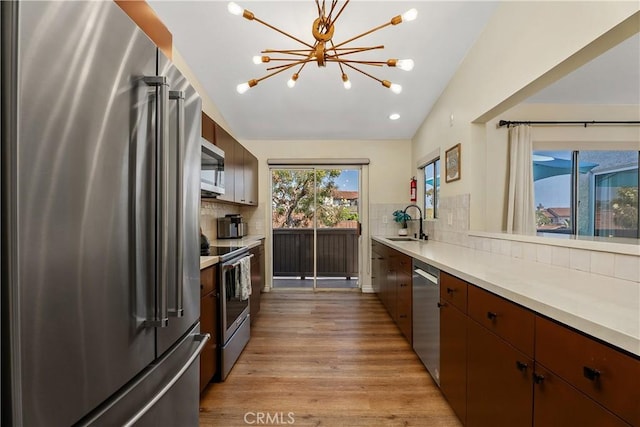 44 Corniche Dr Unit G, Dana Point, CA 92629 - kitchen with stainless steel appliances, light wood-type flooring, tasteful backsplash, a sink, and recessed lighting