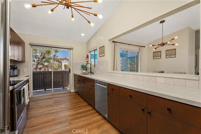 44 Corniche Dr Unit G, Dana Point, CA 92629 - kitchen with a chandelier, appliances with stainless steel finishes, a sink, lofted ceiling, and light wood-style floors