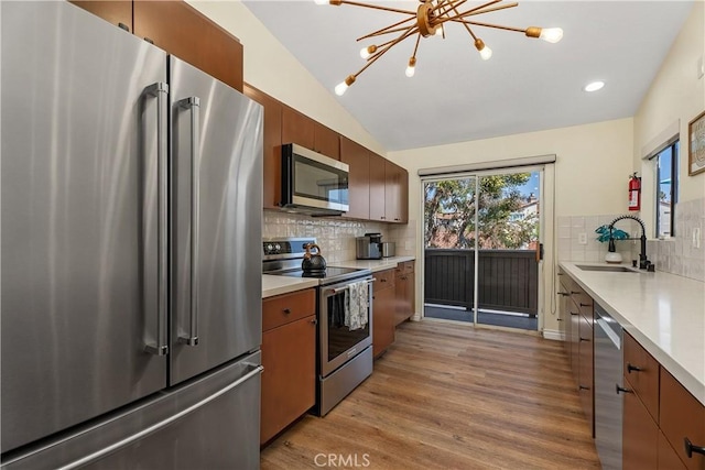 44 Corniche Dr Unit G, Dana Point, CA 92629 - kitchen featuring appliances with stainless steel finishes, a sink, light countertops, light wood-style flooring, and tasteful backsplash