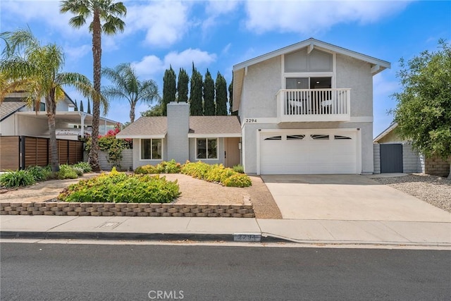traditional home featuring a balcony, stucco siding, a garage, and concrete driveway