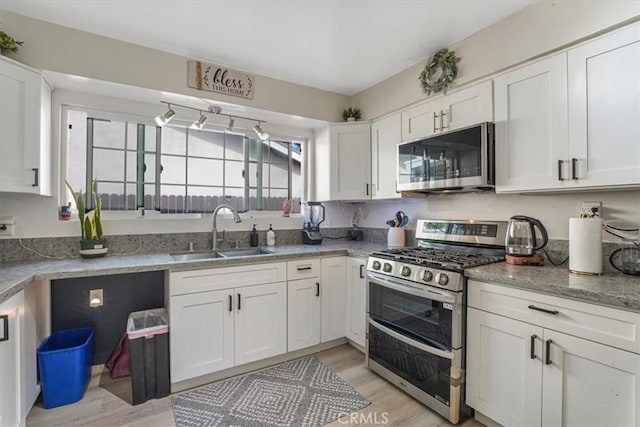 2111 Sanford St, Oxnard, CA 93033 - kitchen with a sink, stainless steel appliances, light wood-style flooring, and white cabinets