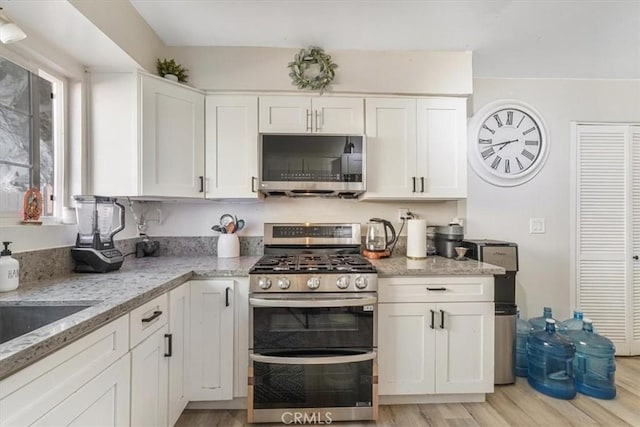2111 Sanford St, Oxnard, CA 93033 - kitchen with light stone counters, stainless steel appliances, white cabinets, and light wood-style flooring