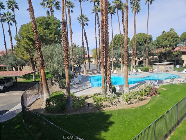 pool featuring a patio area, fence, and a lawn