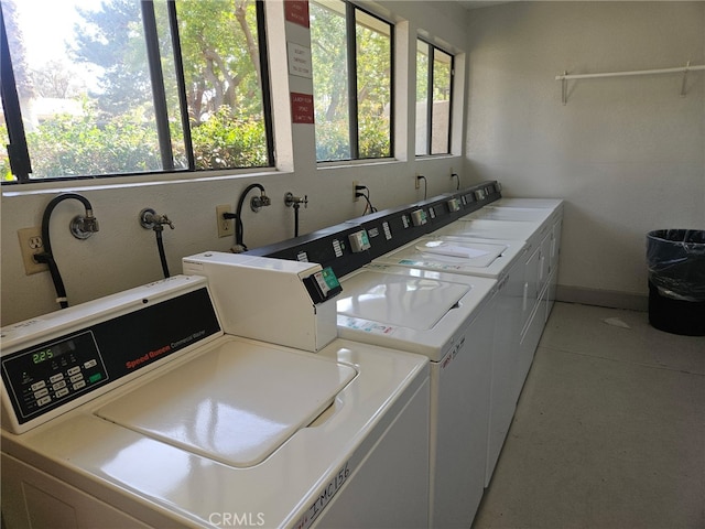 community laundry room featuring washer and clothes dryer and baseboards