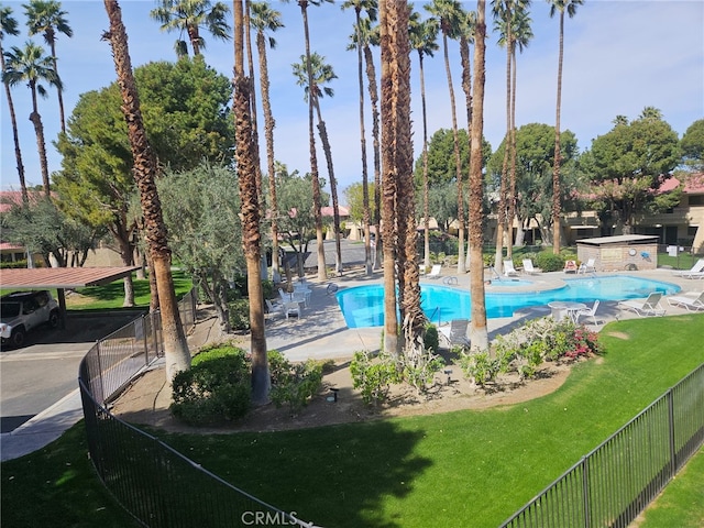 pool featuring a patio area, fence, and a lawn