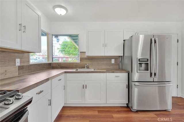 419 San Jacinto St, Redlands, CA 92373 - kitchen featuring white cabinets, stove, stainless steel refrigerator with ice dispenser, and a sink