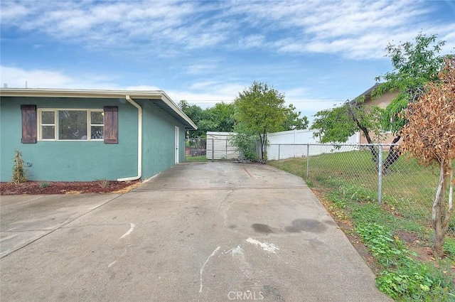 419 San Jacinto St, Redlands, CA 92373 - view of side of property featuring concrete driveway, stucco siding, and fence