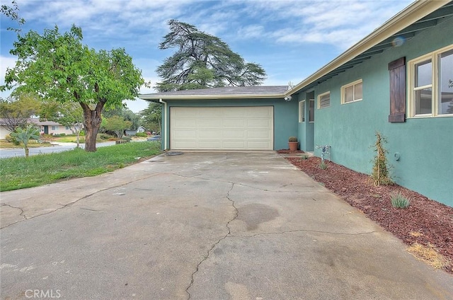 419 San Jacinto St, Redlands, CA 92373 - view of side of property with concrete driveway, stucco siding, and an attached garage