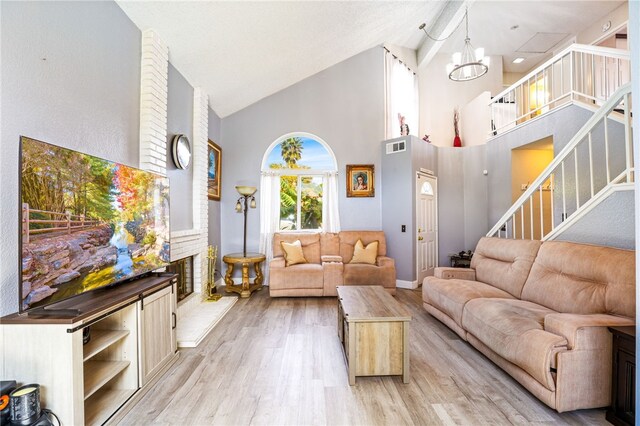 9387 Hot Springs Rd, Corona, CA 92883 - living area with light wood finished floors, an inviting chandelier, visible vents, stairs, and high vaulted ceiling