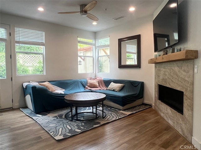 living room featuring ceiling fan, a wealth of natural light, visible vents, and wood finished floors