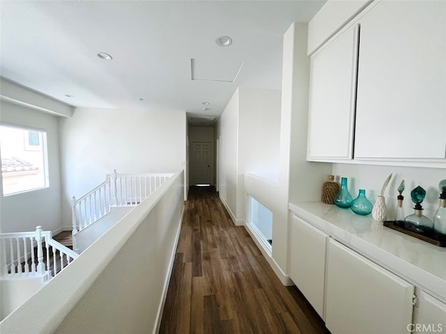 hall featuring dark wood-style flooring, baseboards, an upstairs landing, and recessed lighting