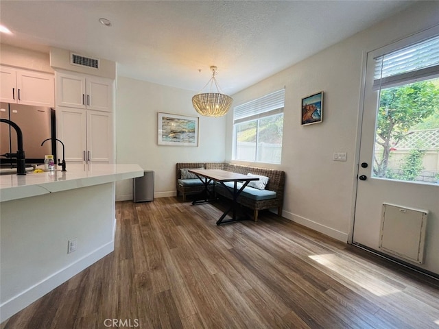 dining room featuring a chandelier, baseboards, dark wood-style floors, and visible vents