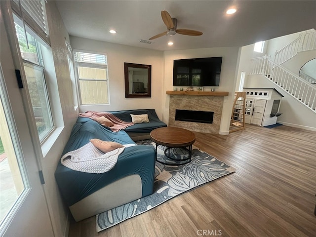 living room with recessed lighting, visible vents, wood finished floors, stairway, and a fireplace