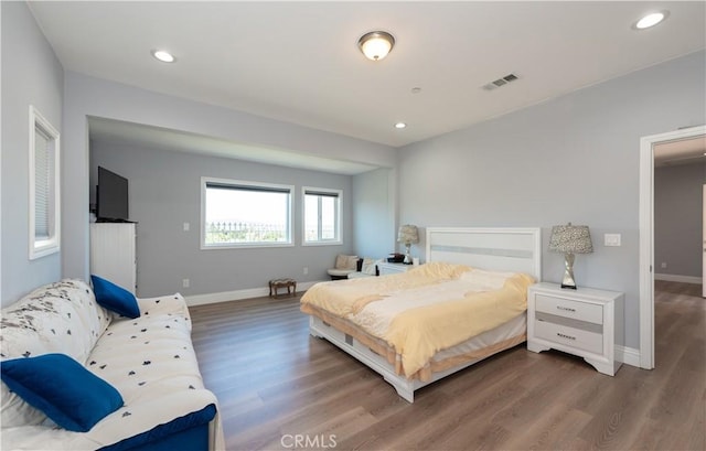 bedroom with visible vents, wood finished floors, baseboards, and recessed lighting