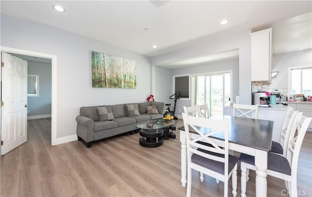 living area with light wood-style flooring, baseboards, and recessed lighting
