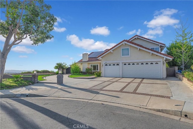 2302 Delfs Ln, Rowland Heights, CA 91748 - view of front of property featuring driveway, solar panels, a tile roof, stucco siding, and an attached garage